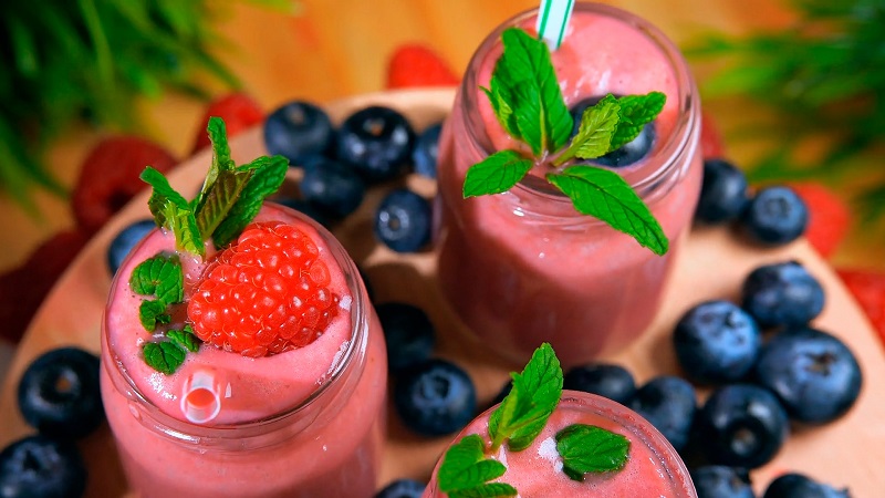 Healthy Smoothie Recipes for a Light Snack Overhead View of Two Glasses Filled with Pink Smoothie Topped with Strawberries and Blueberries