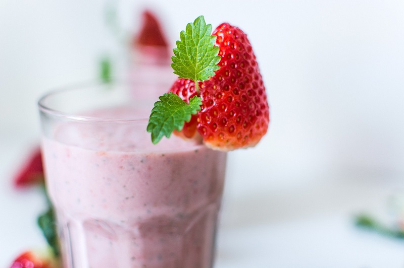 Fat Burning Weight Loss Breakfast Smoothie Recipes Glass Filled with Pink SMoothie with a Strawberry on the Rim