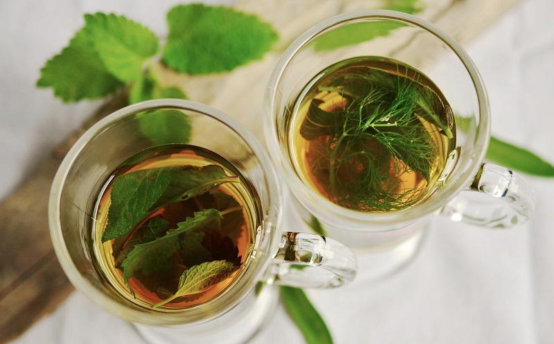 Metabolism Boosting Tea Recipes Overhead View of Two Glasses of Tea with Leaves Around Them