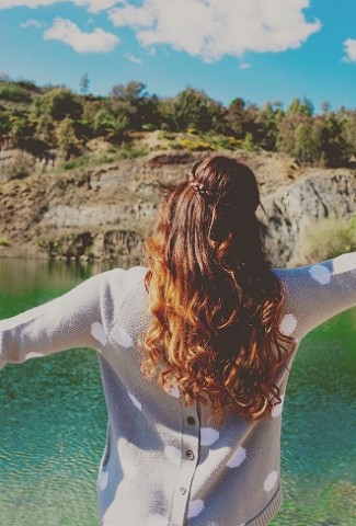 Herbalife Stress Management Product Benefits Woman Standing in Front of a Lake with Her Hands in the Air