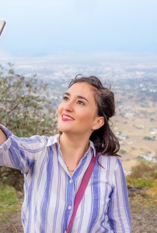 Positivity Captions for Photos of Just Yourself Woman Taking a Selfie on Top of a Hill Overlooking a City
